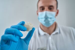 medical-professional-displaying-tooth-crown-in-off-2026-03-10-03-09-36-utc - Encino Gentle Dental Dental Crown