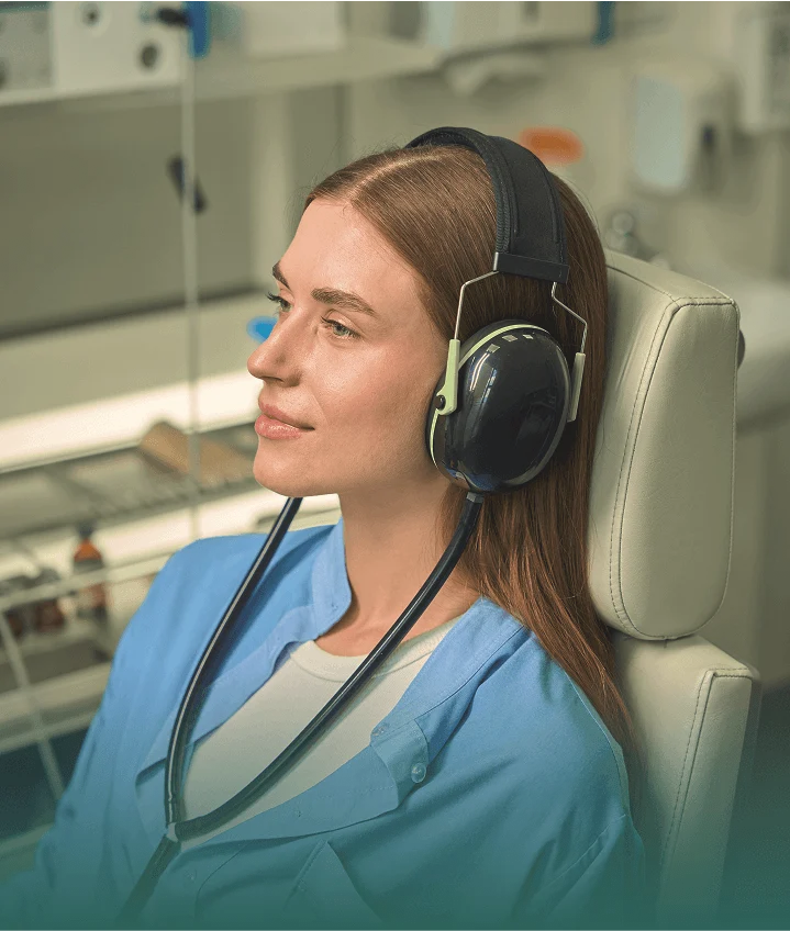 Person relaxing in the dental chair wearing noise-cancelling headphones