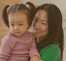 Parent and young child smiling together